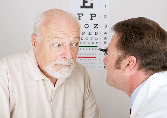 Hoya Vision cataracts optician examining an elderly man's eyes