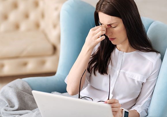 Female suffering from a headache due to digital eyestrain