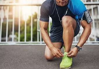 Male tying his running shoe laces