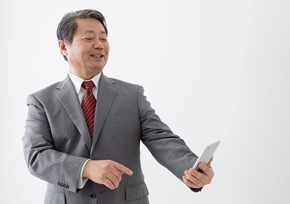 Businessman looking down at his mobile phone from a distance