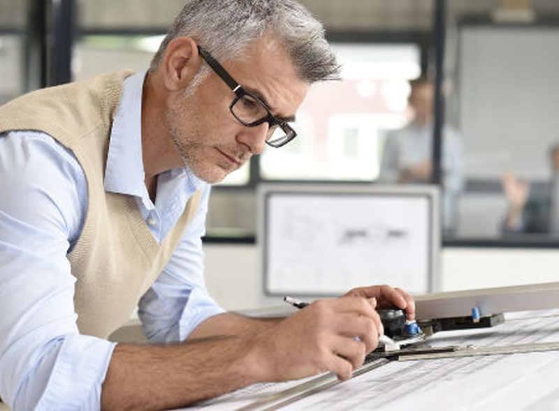 Male working indoors wearing eyeglasses with Hoya Vision indoor lenses