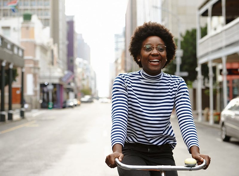 Female riding a bicycle wearing eyeglasses with Hoya Vision single lenses