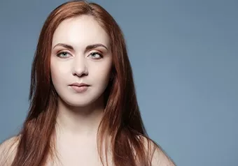 Girl with a squint in front of a blue background