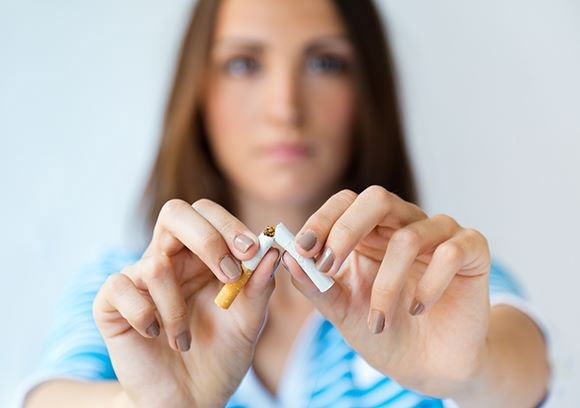 Woman breaking a cigarette in half