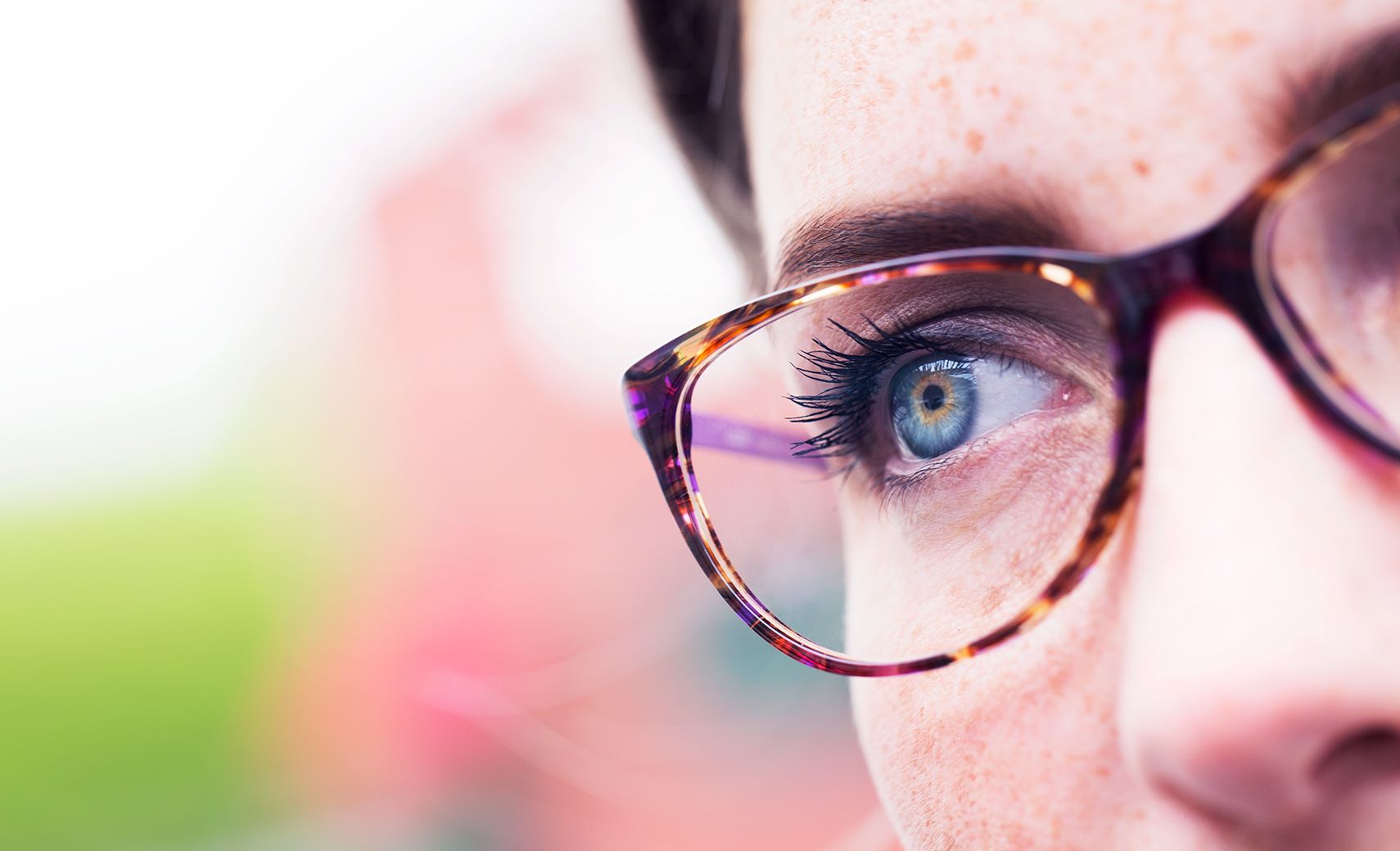 Close up of a woman wearing eyeglasses with Hoya Vision anti reflective lens coating