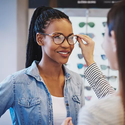 Woman in an optician trying on eyeglasses with Hoya Vision lenses