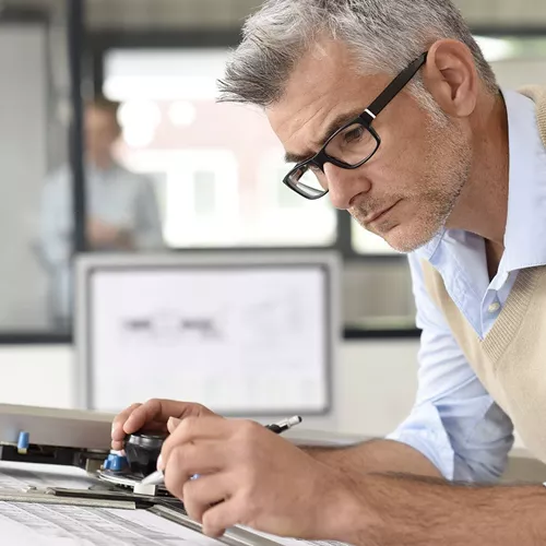 Male architect drawing indoors wearing Hoya Vision indoor lenses 