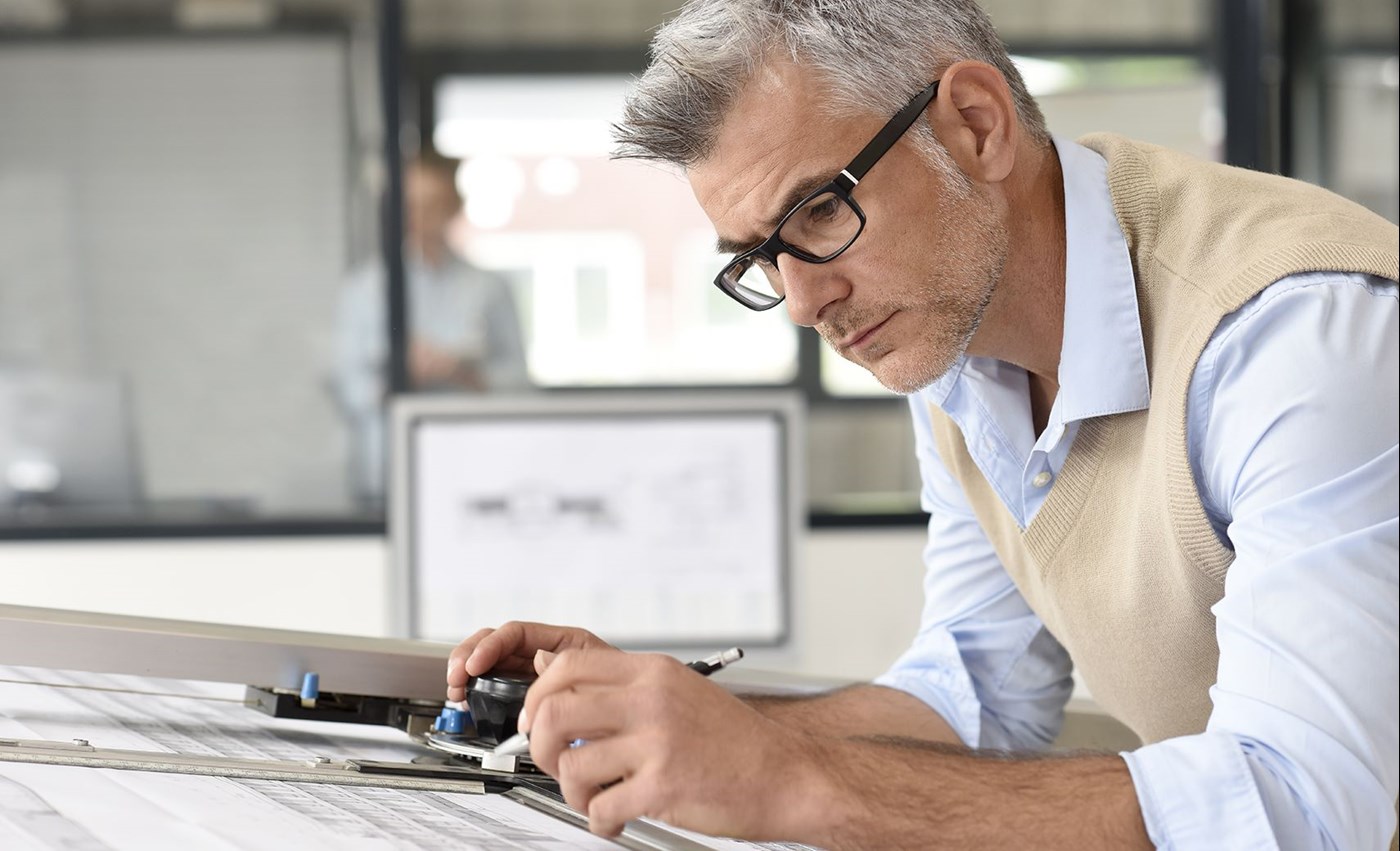 Male architect drawing indoors wearing Hoya Vision indoor lenses