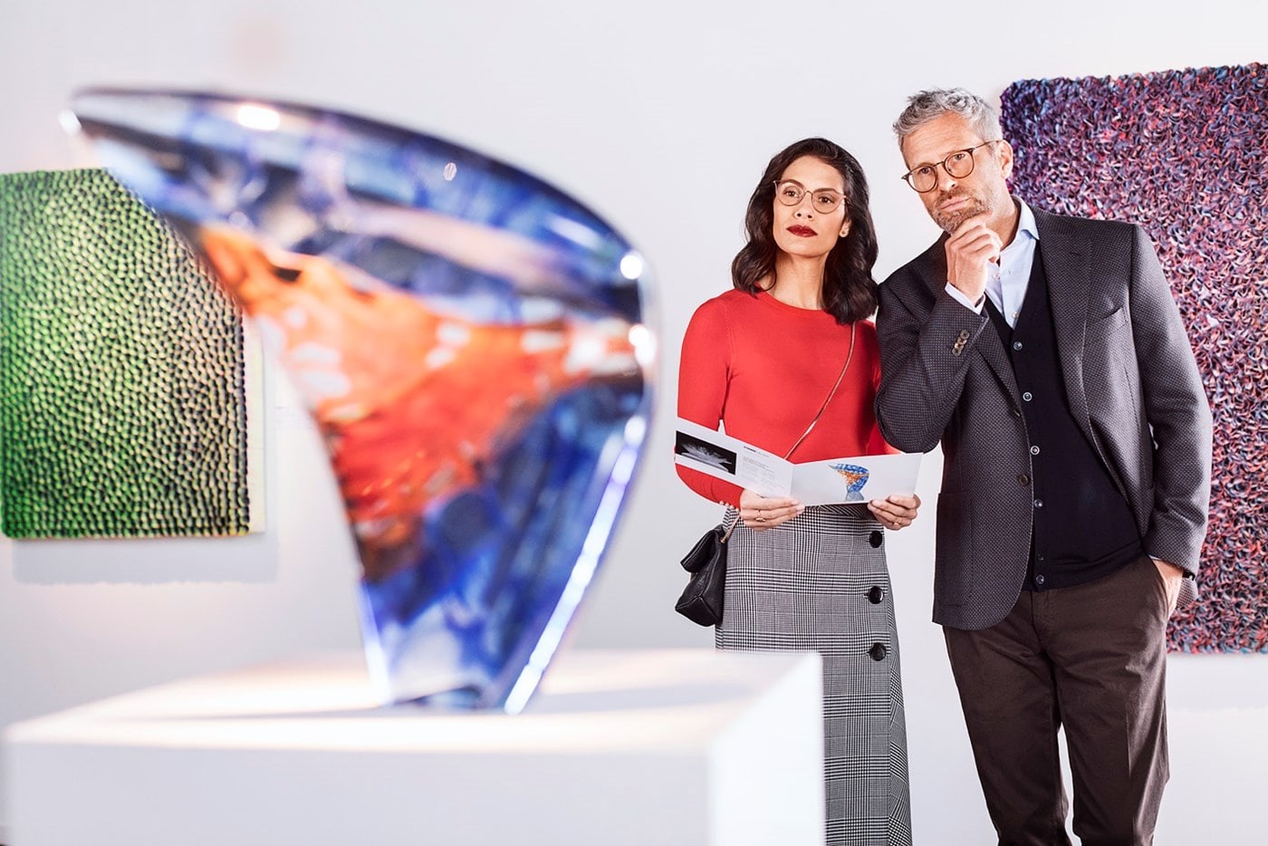 Male and female both wearing eyeglasses with Hoya Vision lenses in an art gallery