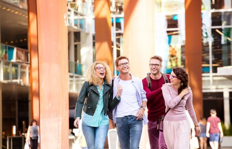 Four people walking and laughing all wearing eyeglasses