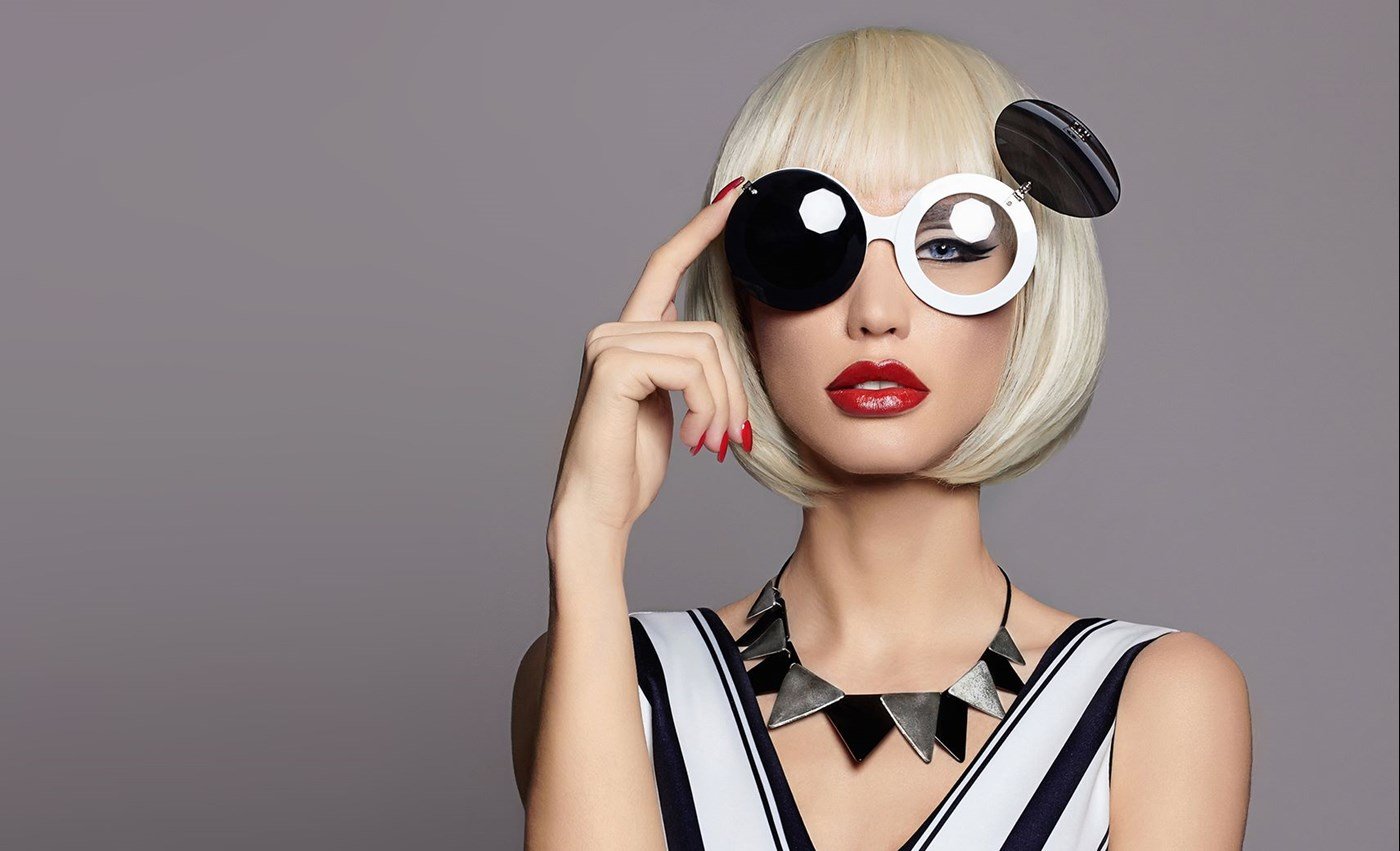 Blonde woman with red lipstick wearing a unique pair of glasses