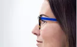Woman wearing blue frames with Hoya Vision lenses