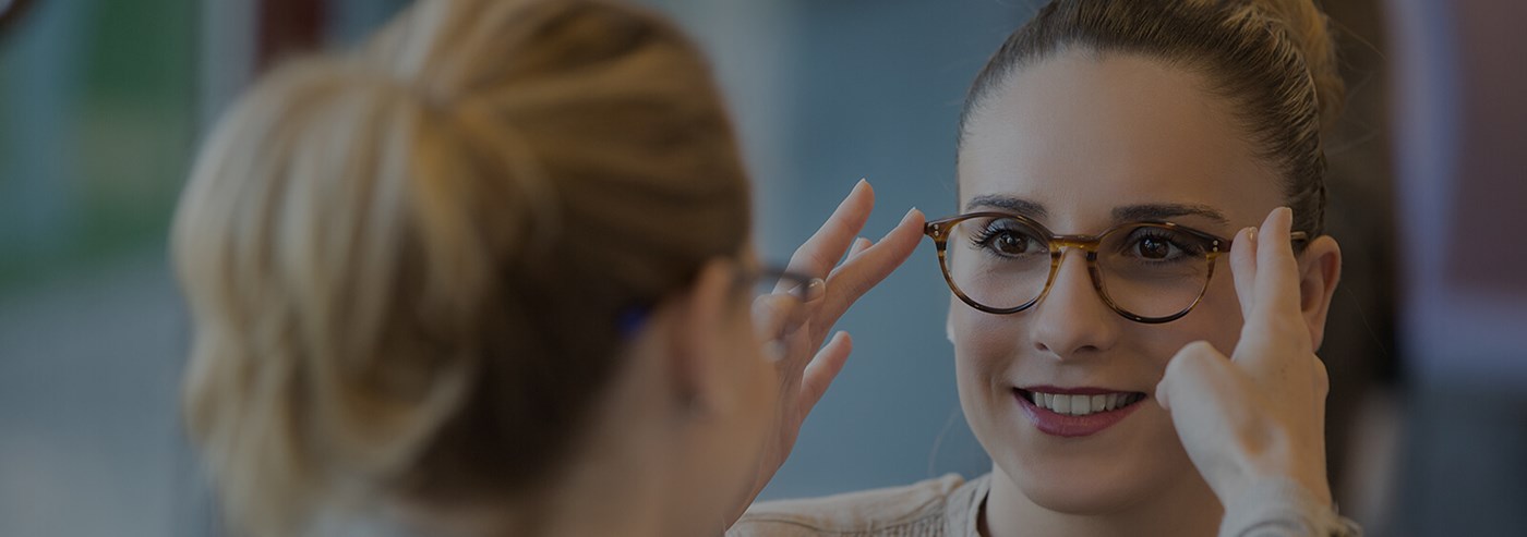 Female Hoya Vision optician placing eyeglasses on a female