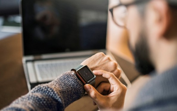 Male looking down at Apple Watch on his left arm