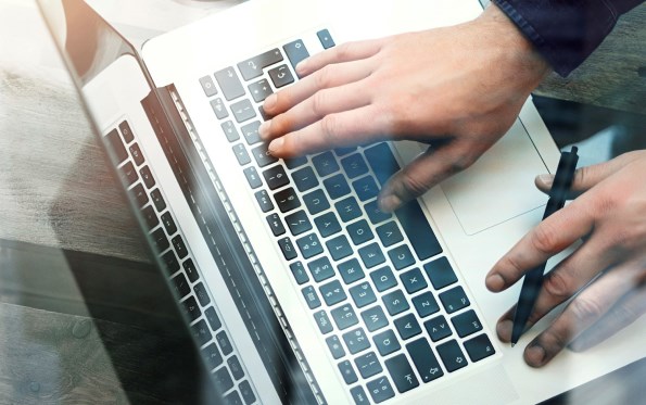Male hands using a laptop keyboard