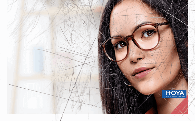 Woman wearing eyeglasses with Hoya Vision lenses behind a scratched screen