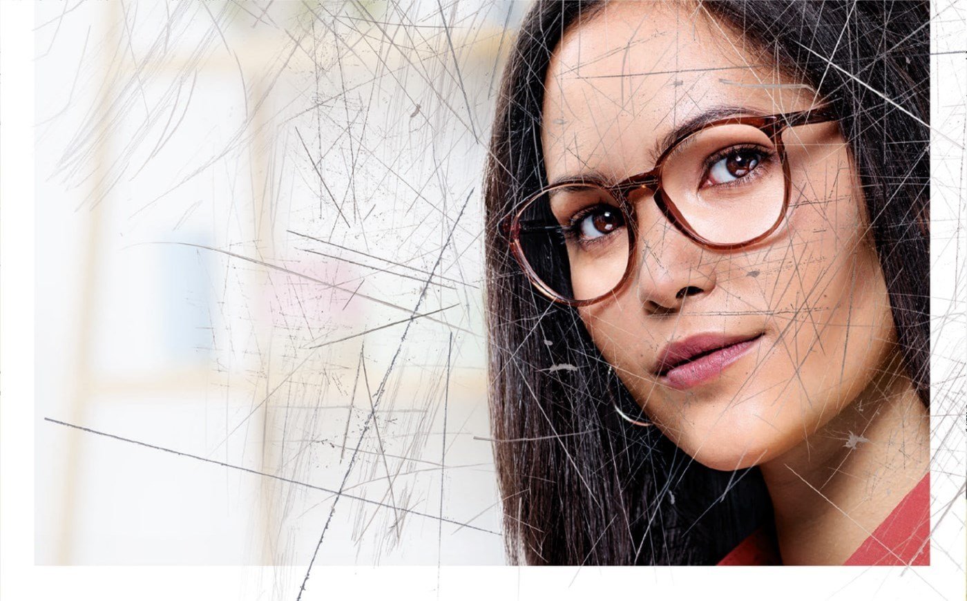 Woman wearing eyeglasses with Hoya Vision lenses behind a scratched screen