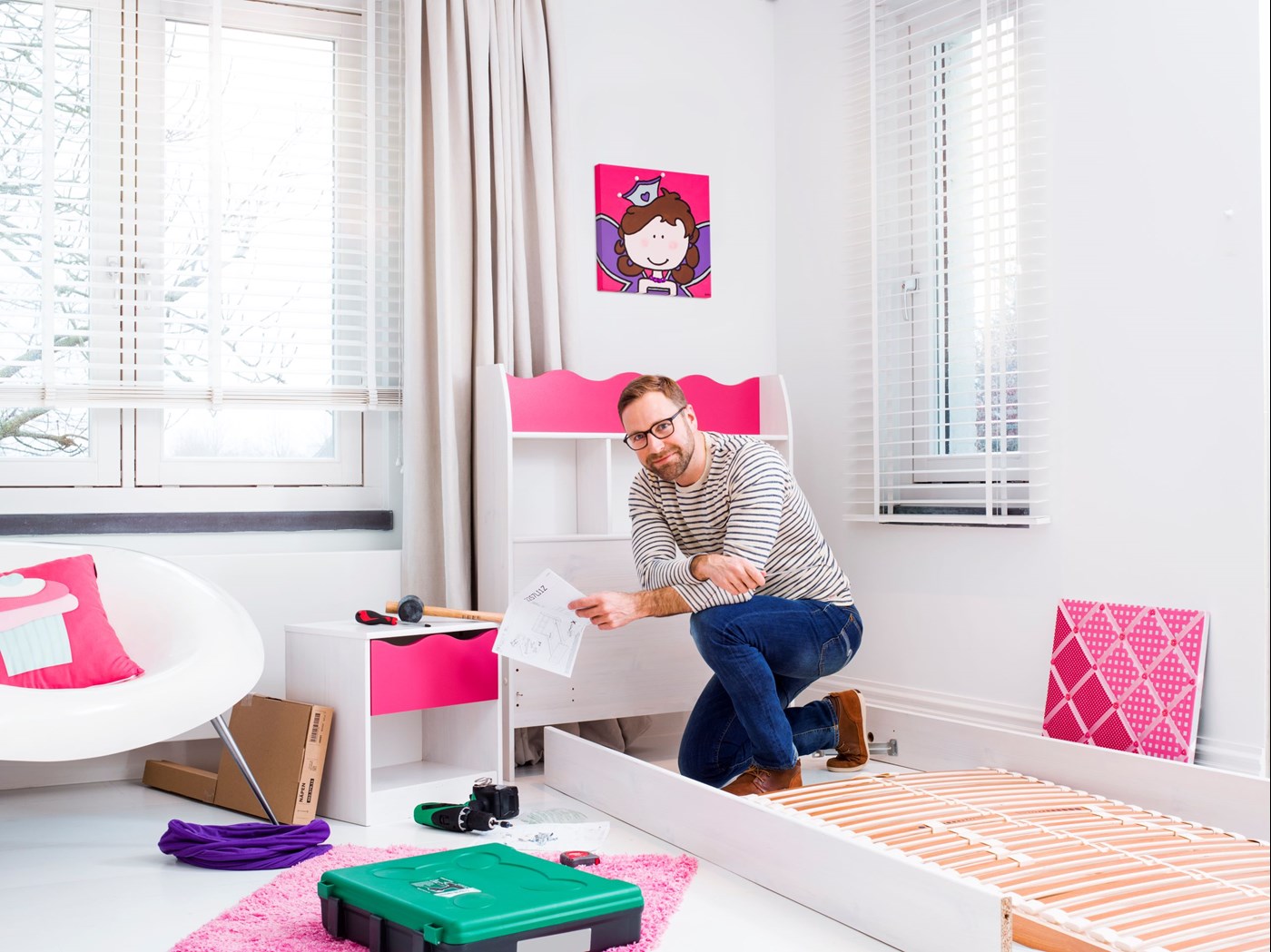 Male wearing eyeglasses building bed frame