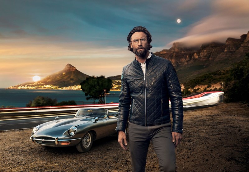 Male wearing eyeglasses infront of vintage car