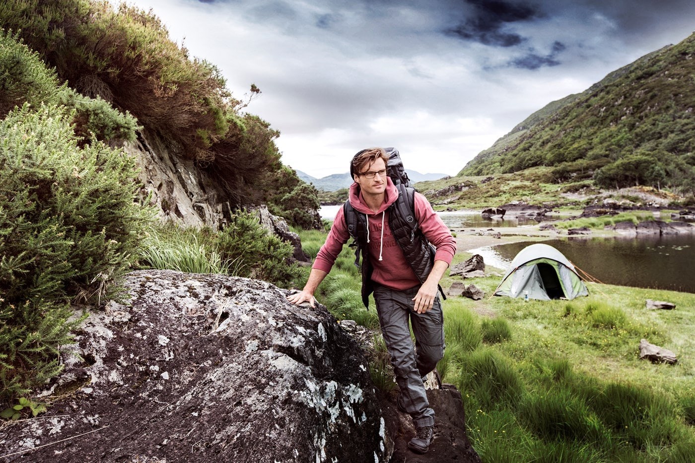 Male mountain climber with backpack and glasses on