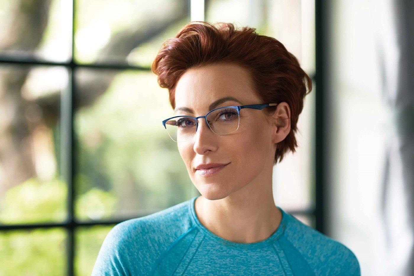 Female in blue top wearing eyeglasses