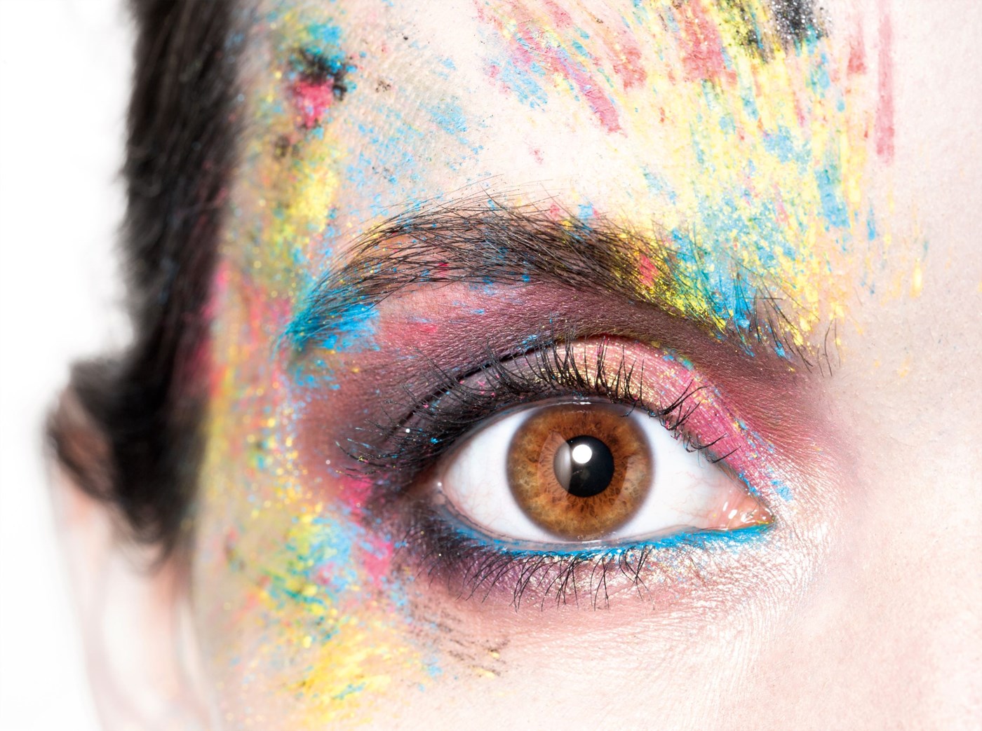 Up close shot of female eye ball with paint splattered over face
