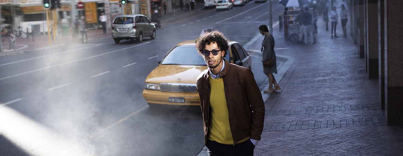 Male wearing dark lenses walking down street