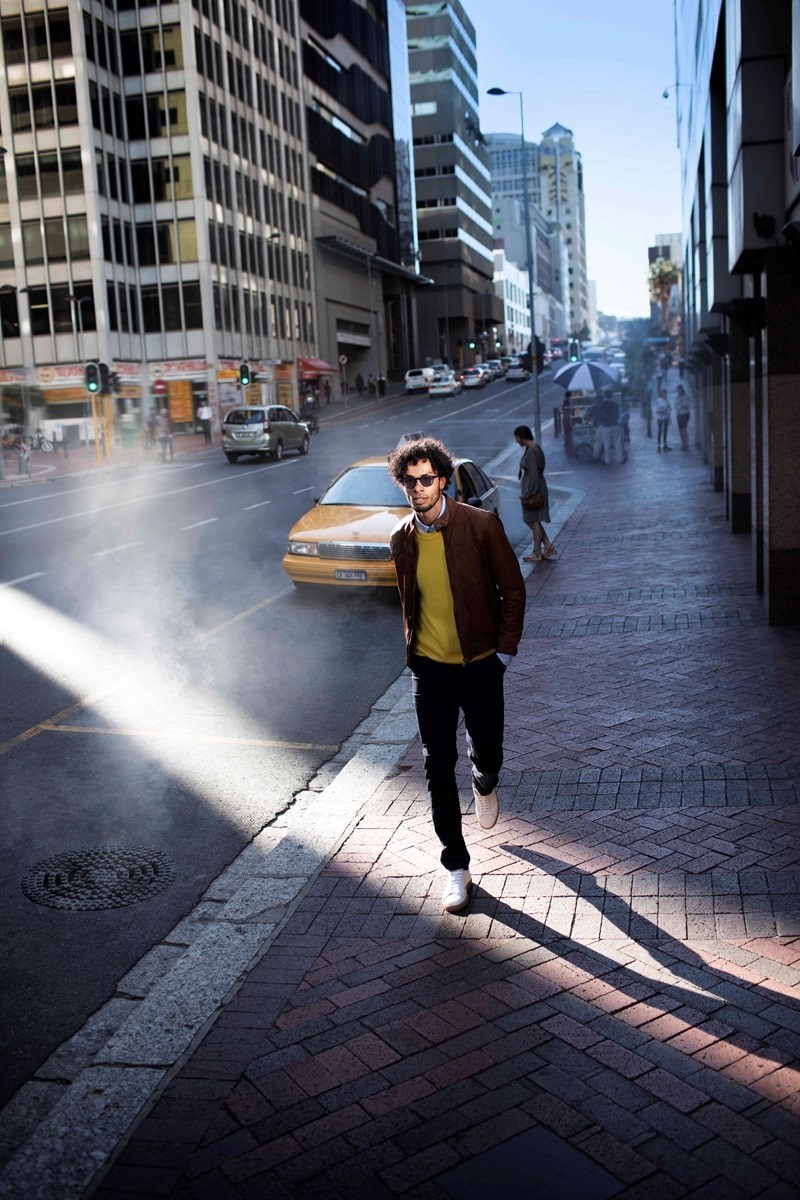 Male wearing dark lenses walking down street